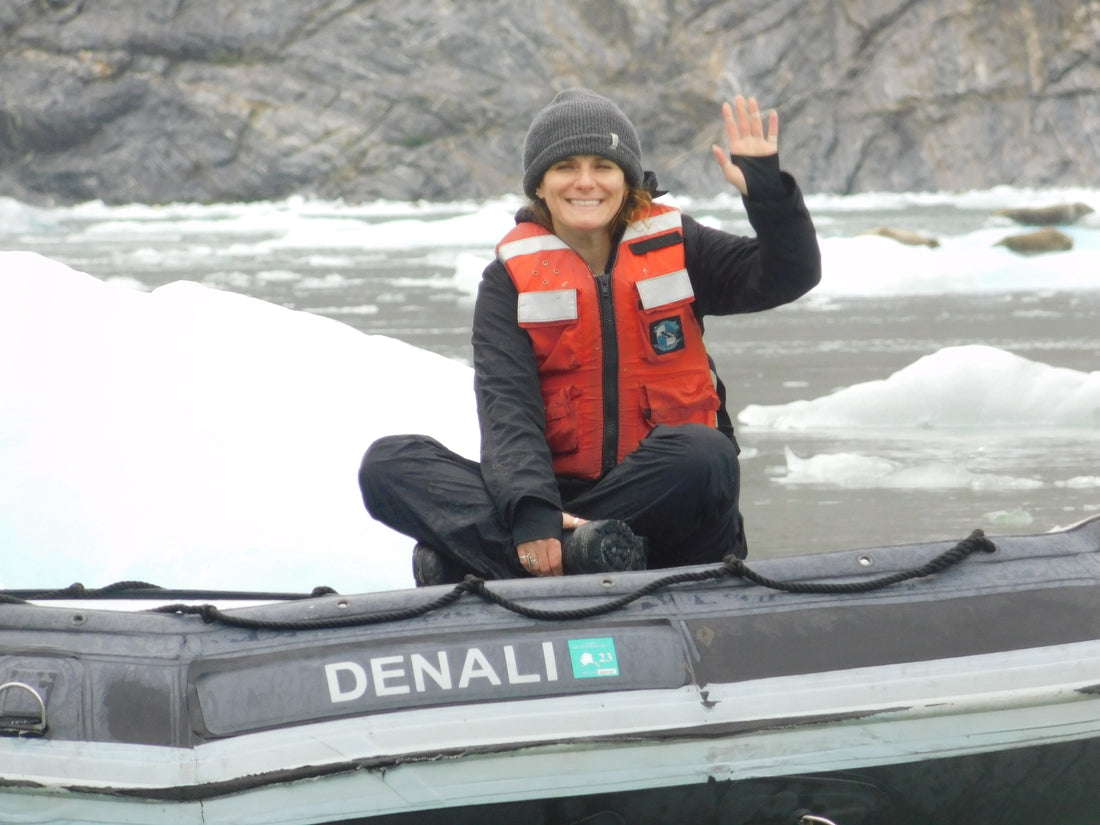 Rachel Caraway waving from a skiff in Alaska