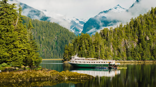 Expedition ship in cove surrounded by trees and mountains-UnCruise Adventures 
