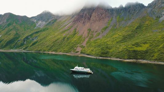 Ship in front of tall mountains in the Aleutian Islands-UnCruise Adventures 